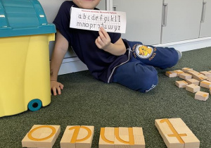 dziecko konstruuje litery z klocków dedykowanych "skutecznemu zdziwieniu"
